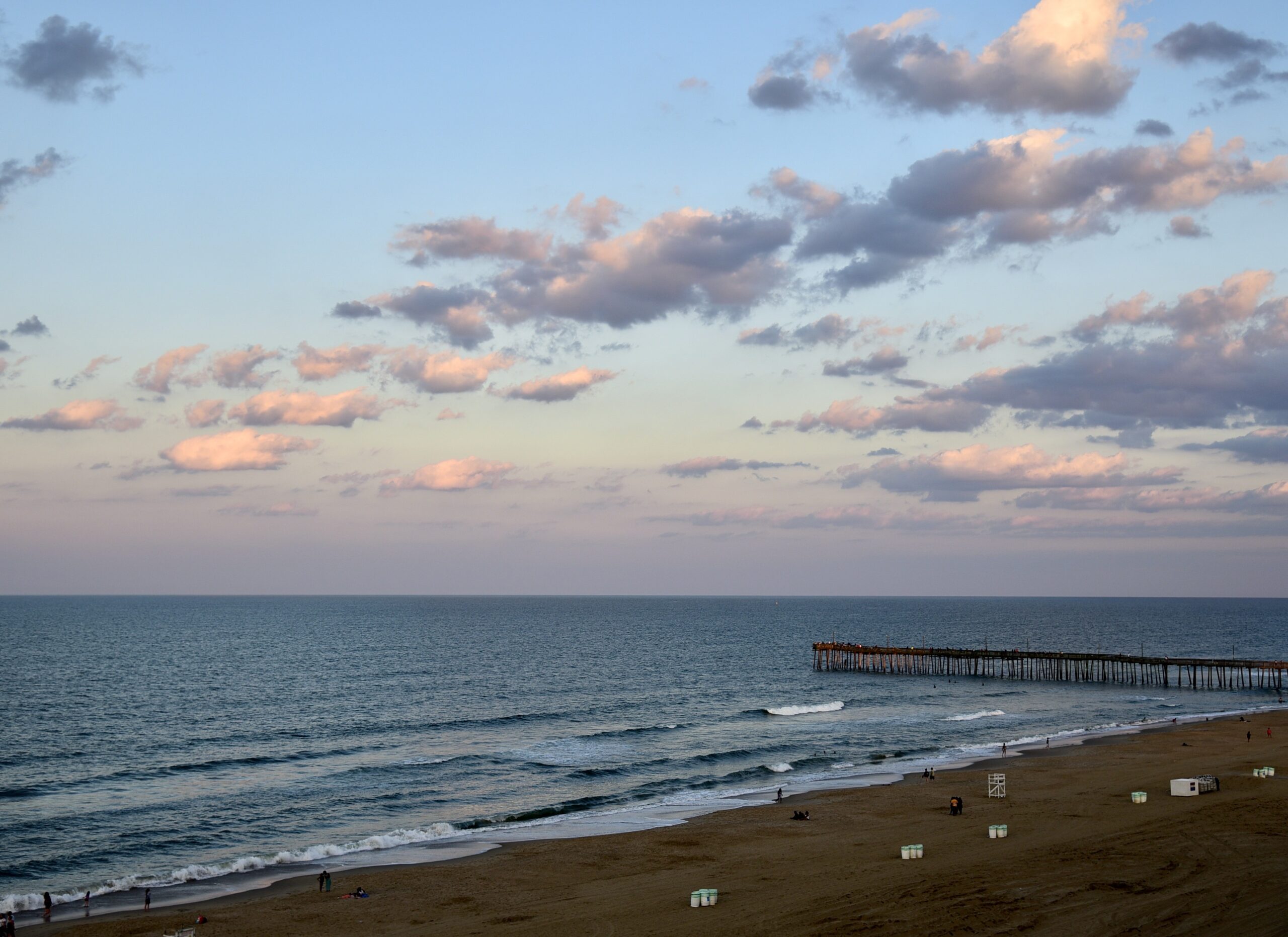 Oceanfront pier in Virginia Beach at sunset with pastel sky over the beach